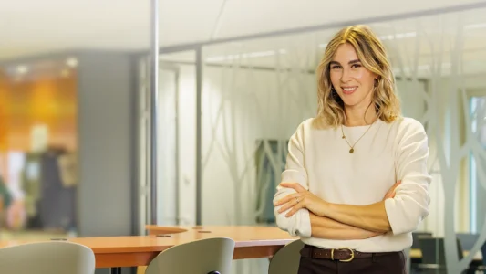 Decoratieve foto van een vrouwelijke collega van de Regionale Belasting groep, welke direct in de camera kijkt.