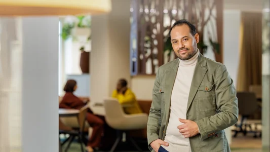 Decoratieve foto van een mannelijke collega van de Regionale Belasting groep, welke direct in de camera kijkt.